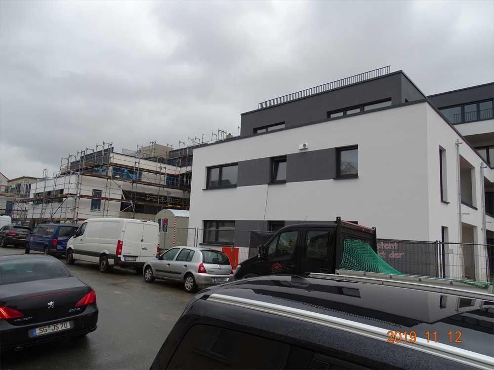 Eine Reihe von Autos parkt vor einem im Bau befindlichen Gebäude