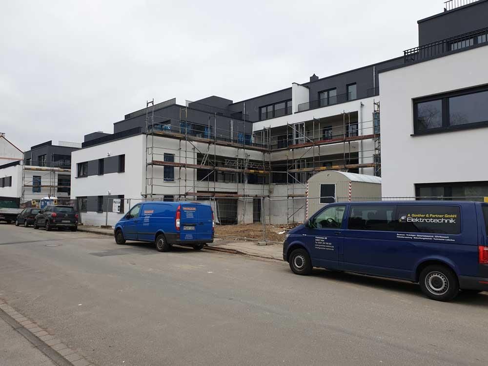 Ein blauer Lieferwagen steht vor einem im Bau befindlichen Gebäude