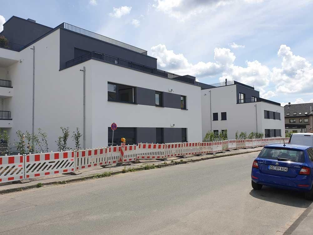 Ein blaues Auto steht vor einem Gebäude, das sich im Bau befindet