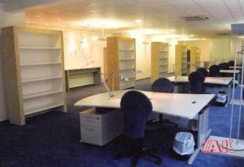 Ein Raum mit vielen Schreibtischen und Stühlen.