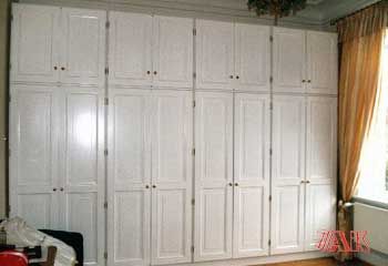 Ein Raum mit vielen weißen Schränken und einem Fenster.