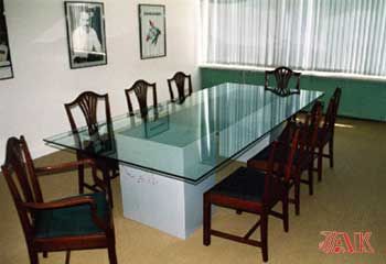 Ein Konferenzraum mit einem langen Glastisch und Stühlen