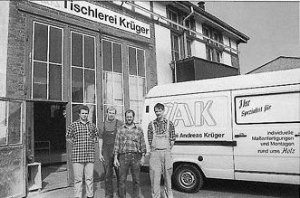 Eine Gruppe von Männern steht vor einem Lieferwagen mit der Aufschrift ak
