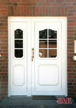 Eine weiße Tür befindet sich an einer Backsteinmauer neben einem Briefkasten.