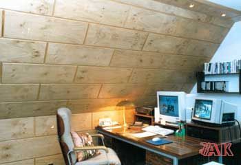 Ein Raum mit einer Holzwand und einem Schreibtisch mit zwei Computern darauf