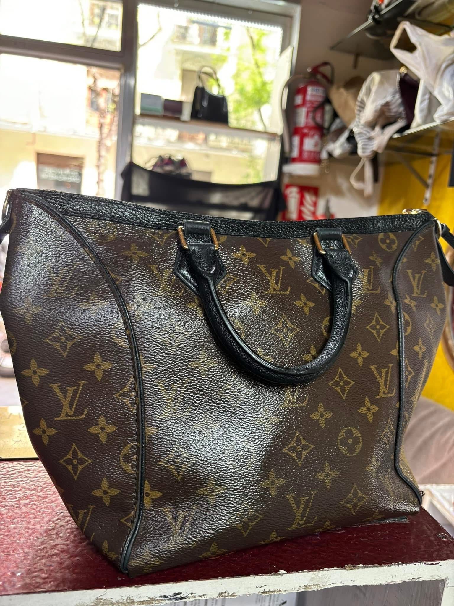 Bolsa tote marrón estampada con asas negras sobre una encimera en una habitación