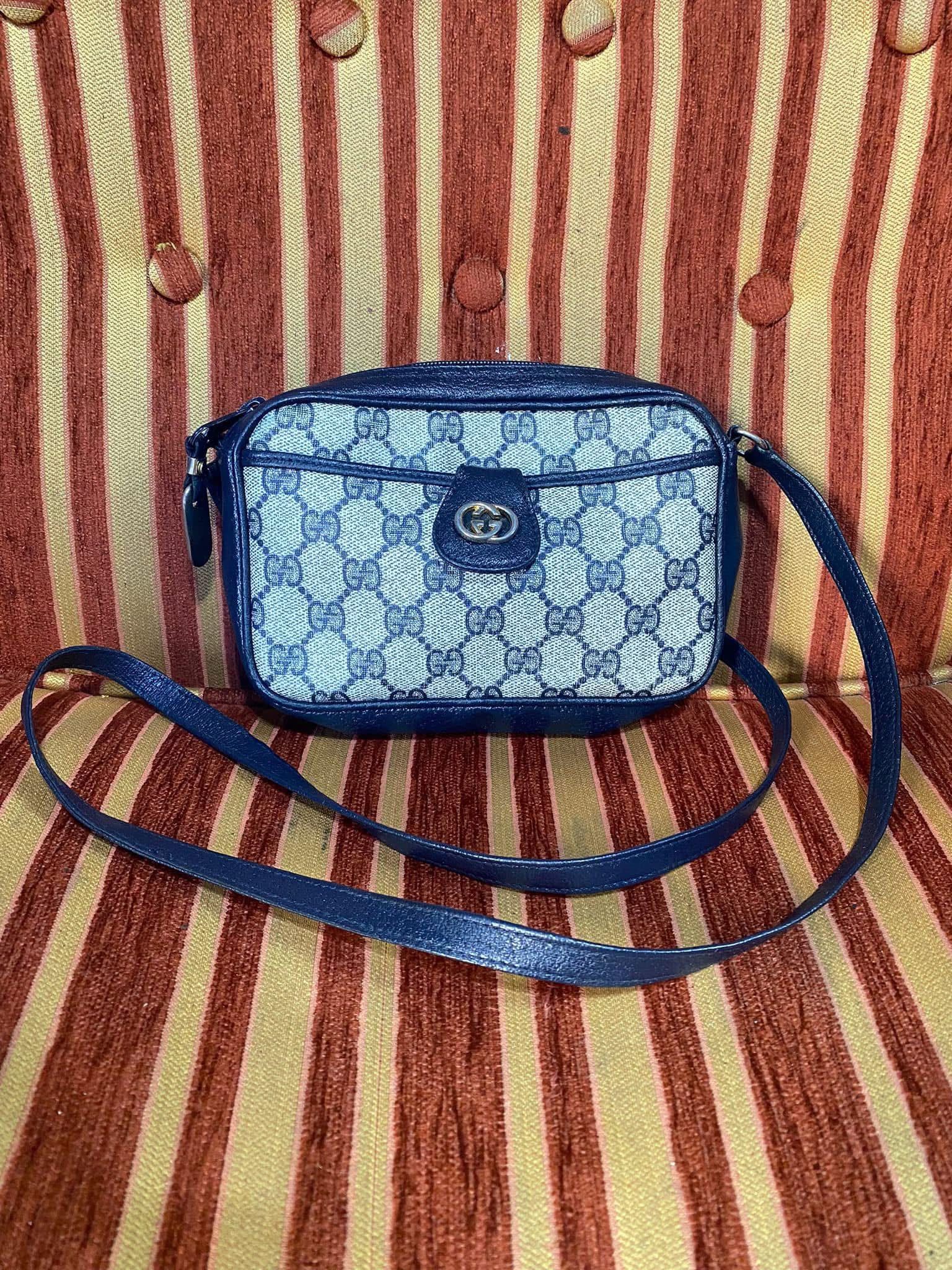 Bolso bandolera azul estampado sobre un fondo de rayas rojas y color crema
