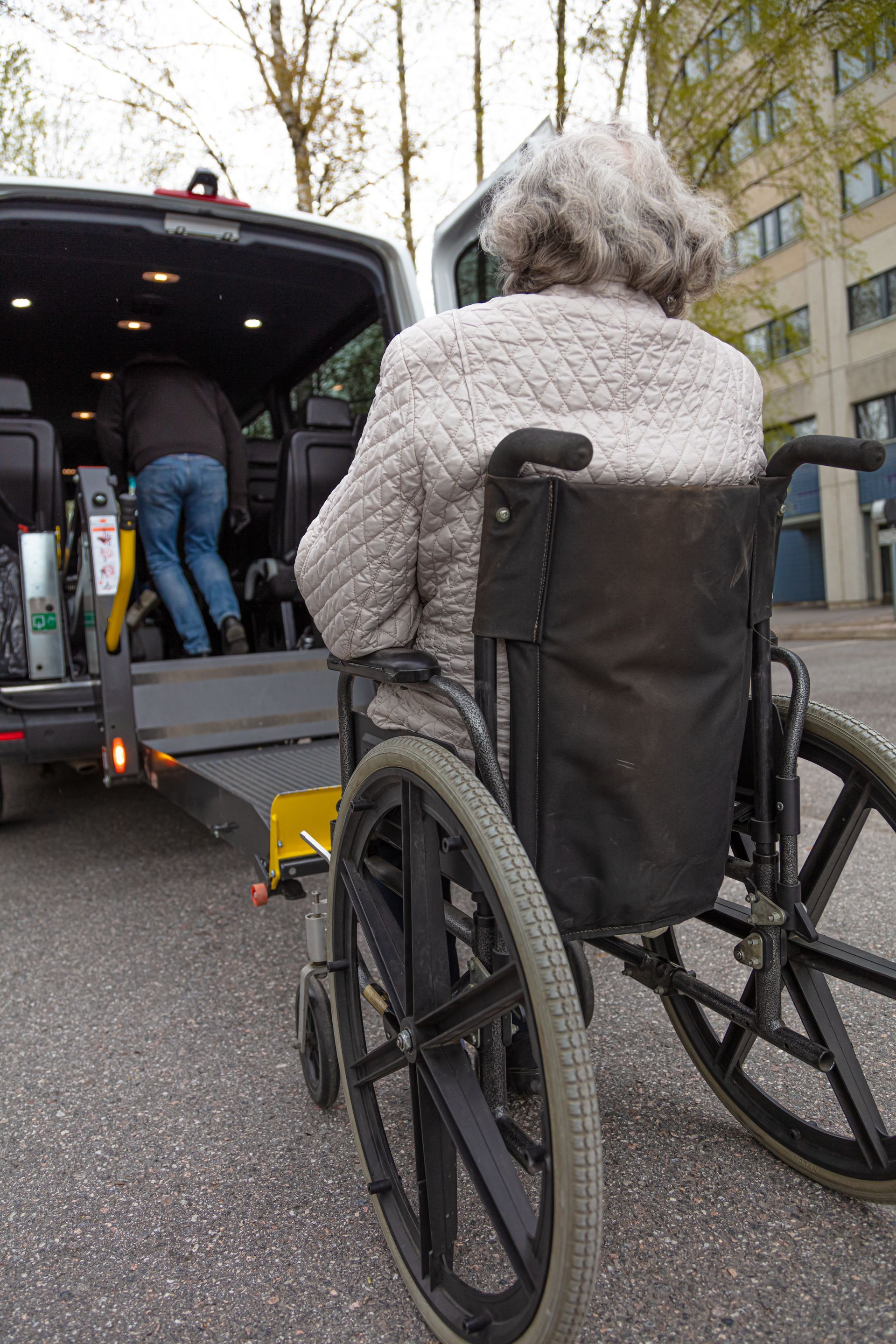 Photo d'une femme en fauteuil roulant et d'un véhicule TPMR