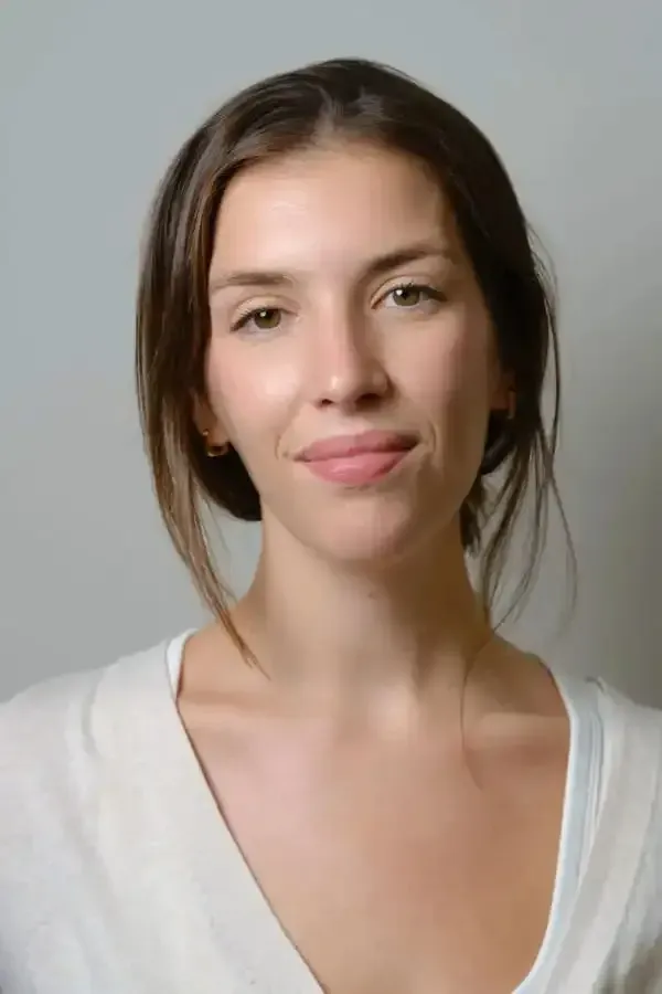 Mujer de piel clara, vestida con un suéter blanco