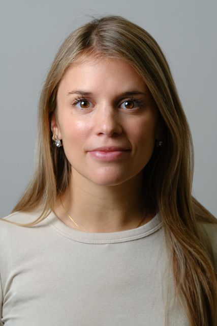 Mujer rubia de pelo largo, vestida con un suéter marrón