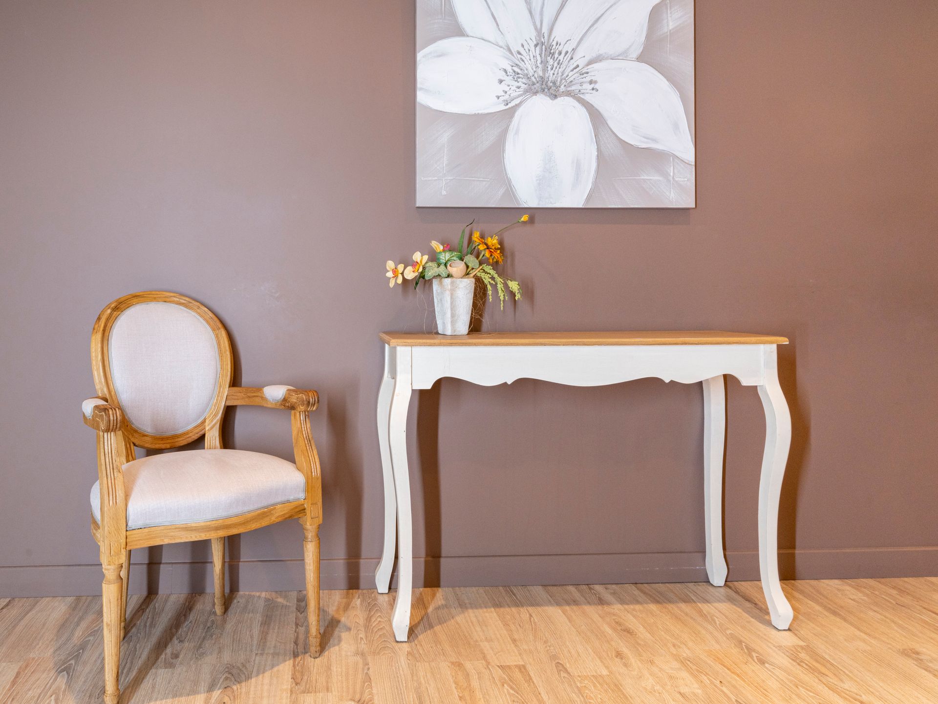 Intérieur d'un salon funéraire avec une chaise, un petit meuble et de la décoration florale