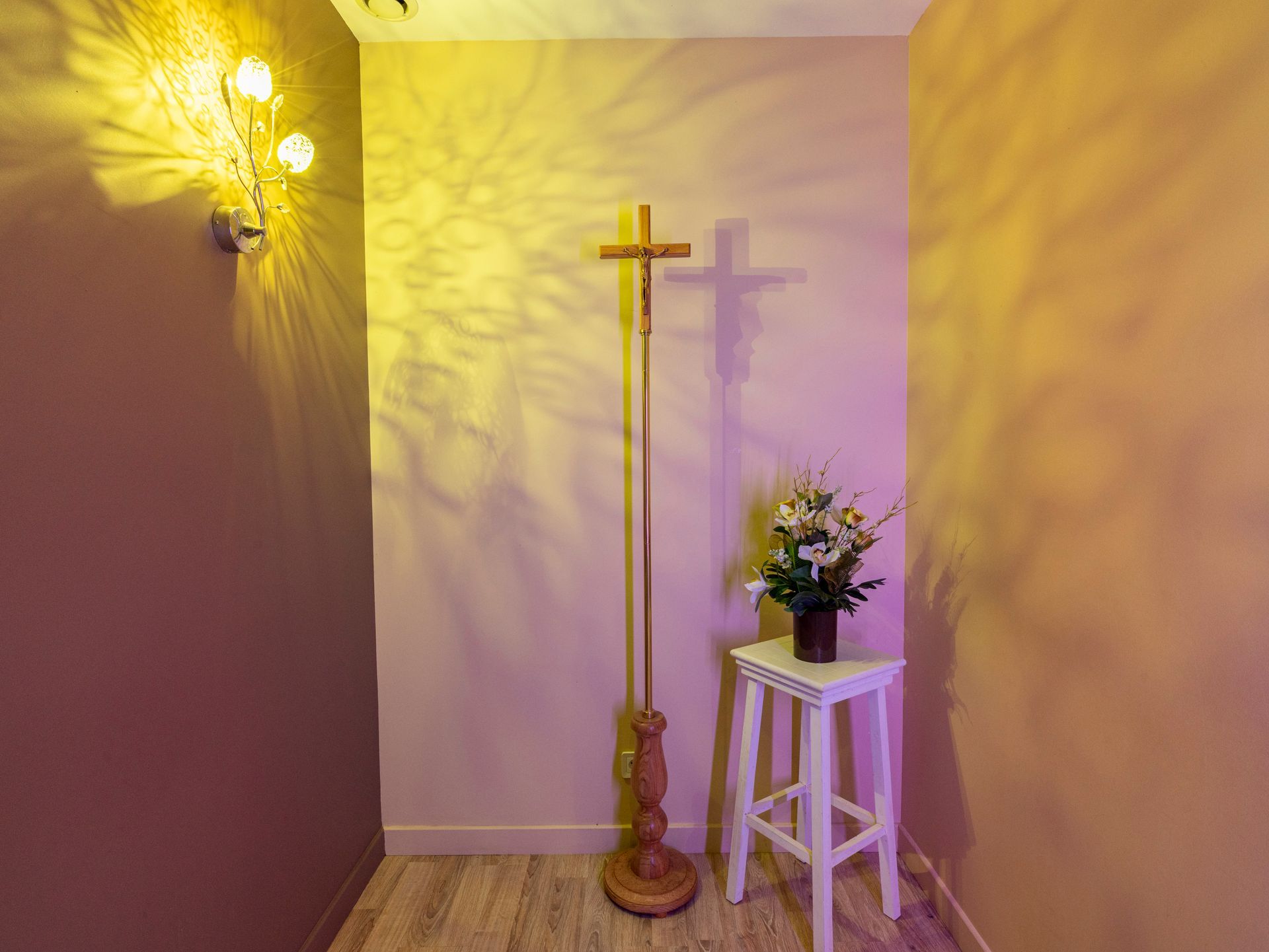 Croix religieuse dans un salon funéraire avec composition florale