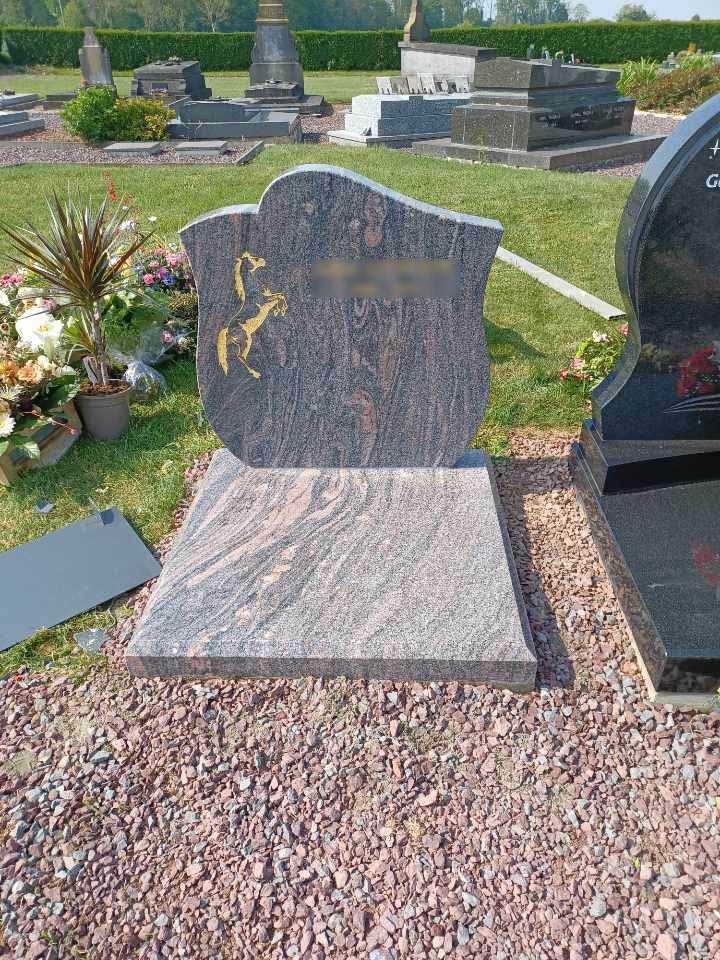 Tombe avec une inscription dorée et la silhouette d'un cheval incrusté