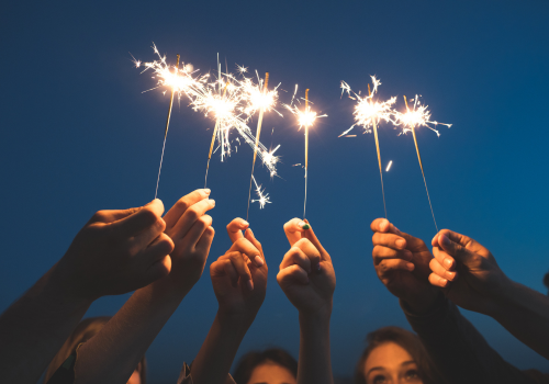 group of friends with sparklers celebrating the new year