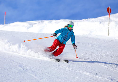 someone skiing down the snowy mountain on a clear, sunny day