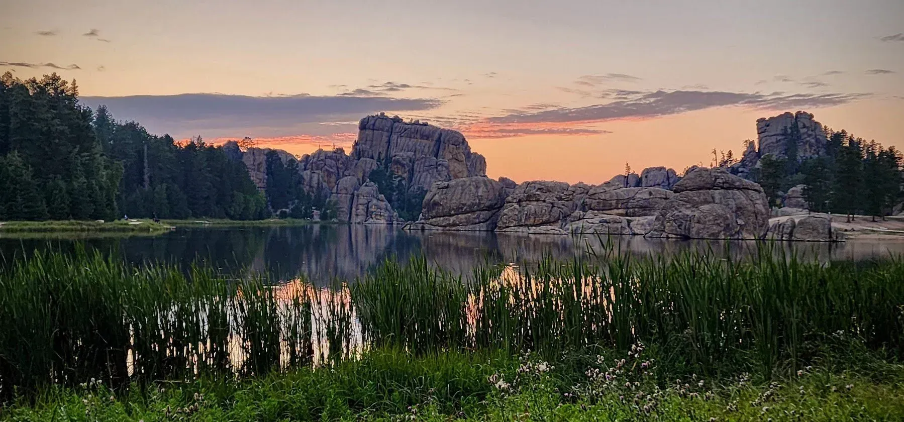Natural lake in the Black Hills with a rocky landscape on the horizon
