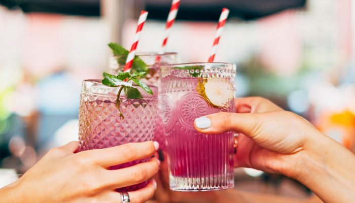 Group of friends cheering their drinks together on a nice day outside 