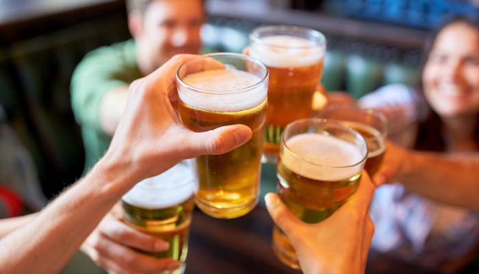 Friends cheering beer glasses in a bar