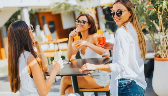 group of girls enjoying outside weather with cocktails