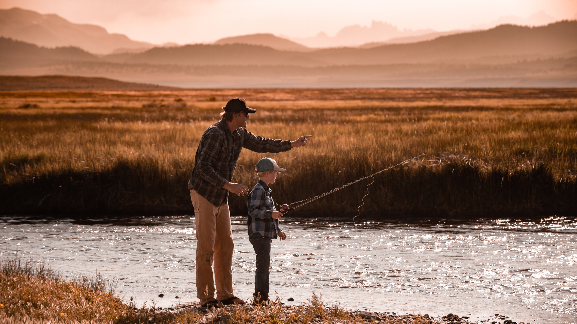Father and son fishing together at a remote country river