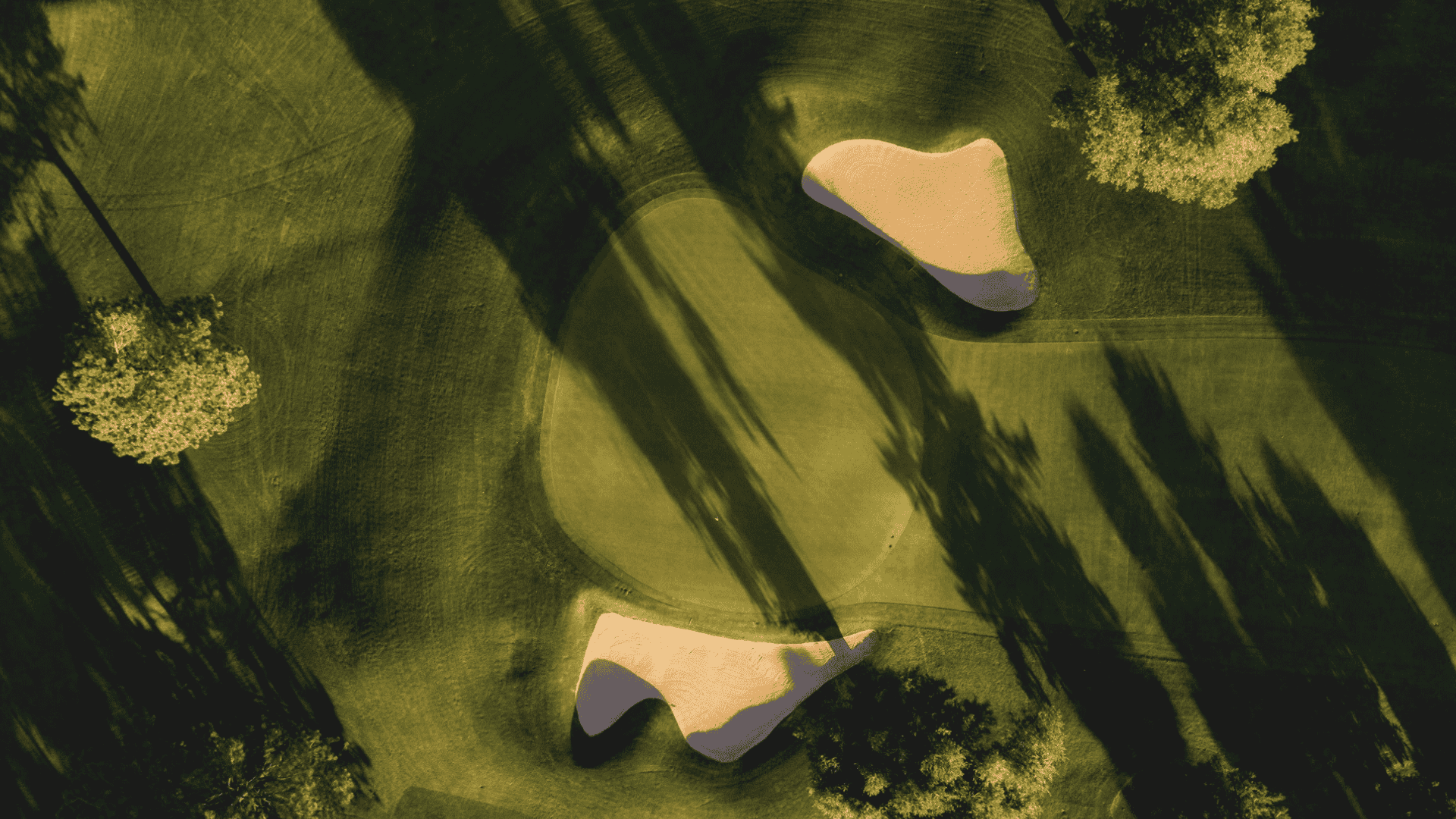 Ariel shot of the green golf course with sand pits on a sunny day