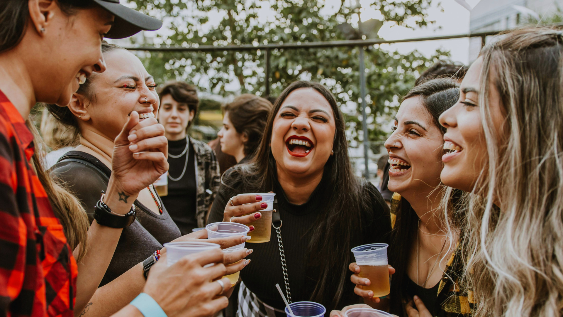 Group of people enjoying each other in conversation while drinking alcohol at a festival