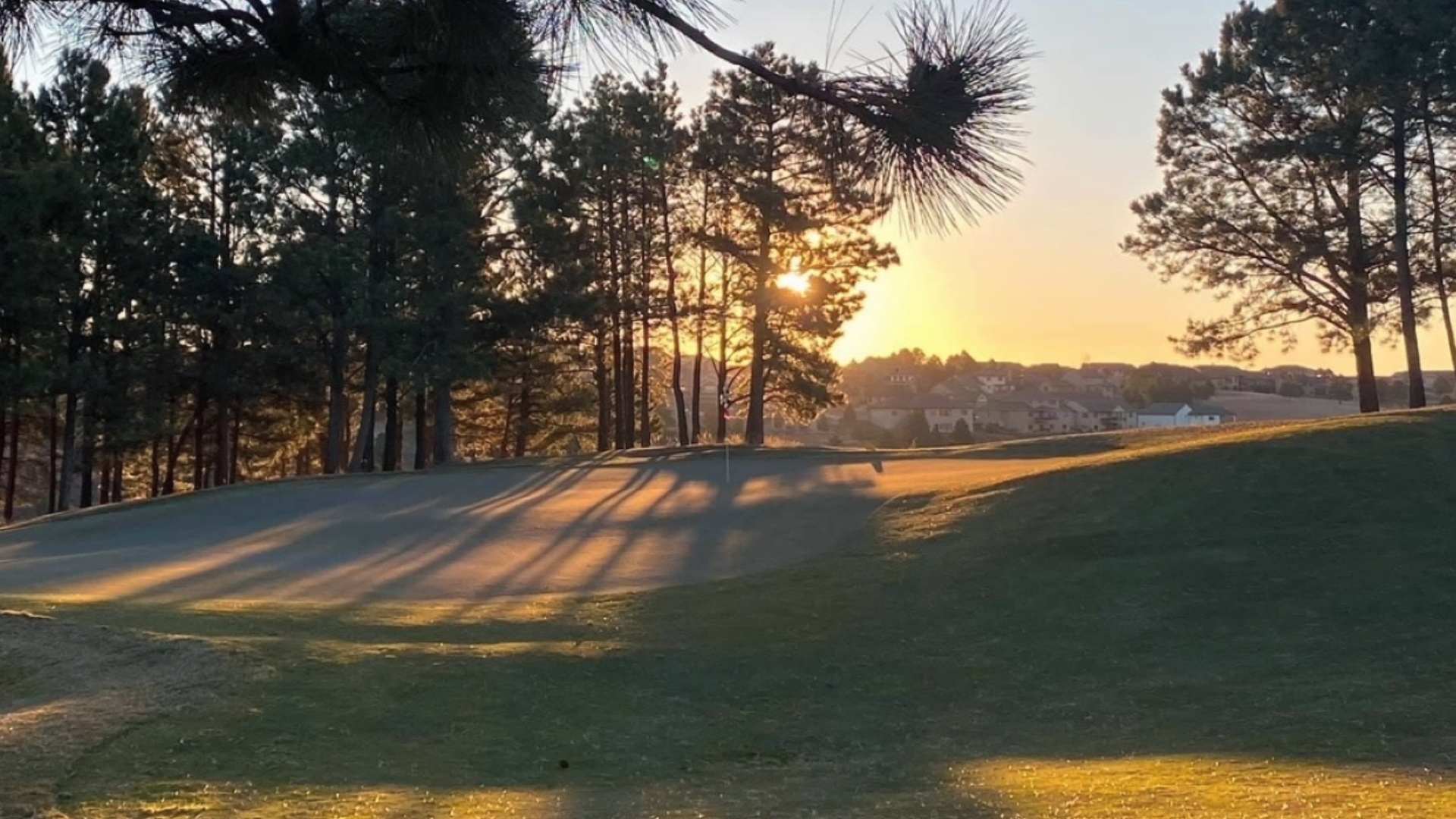 Golf Club at Red Rock with rolling green fairways framed by evening light