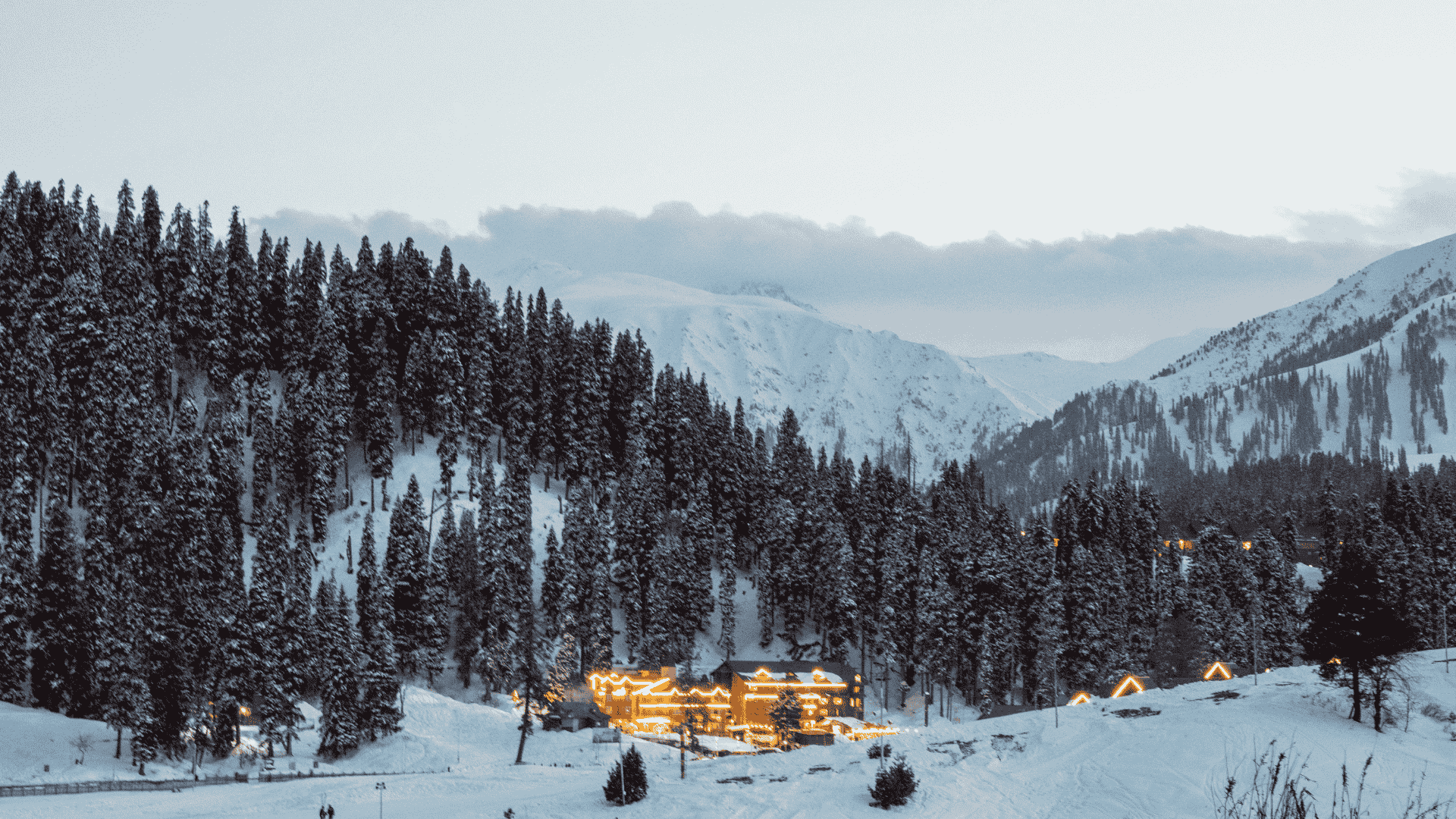 Snow-covered winter landscape and a scenic resort lit up at night