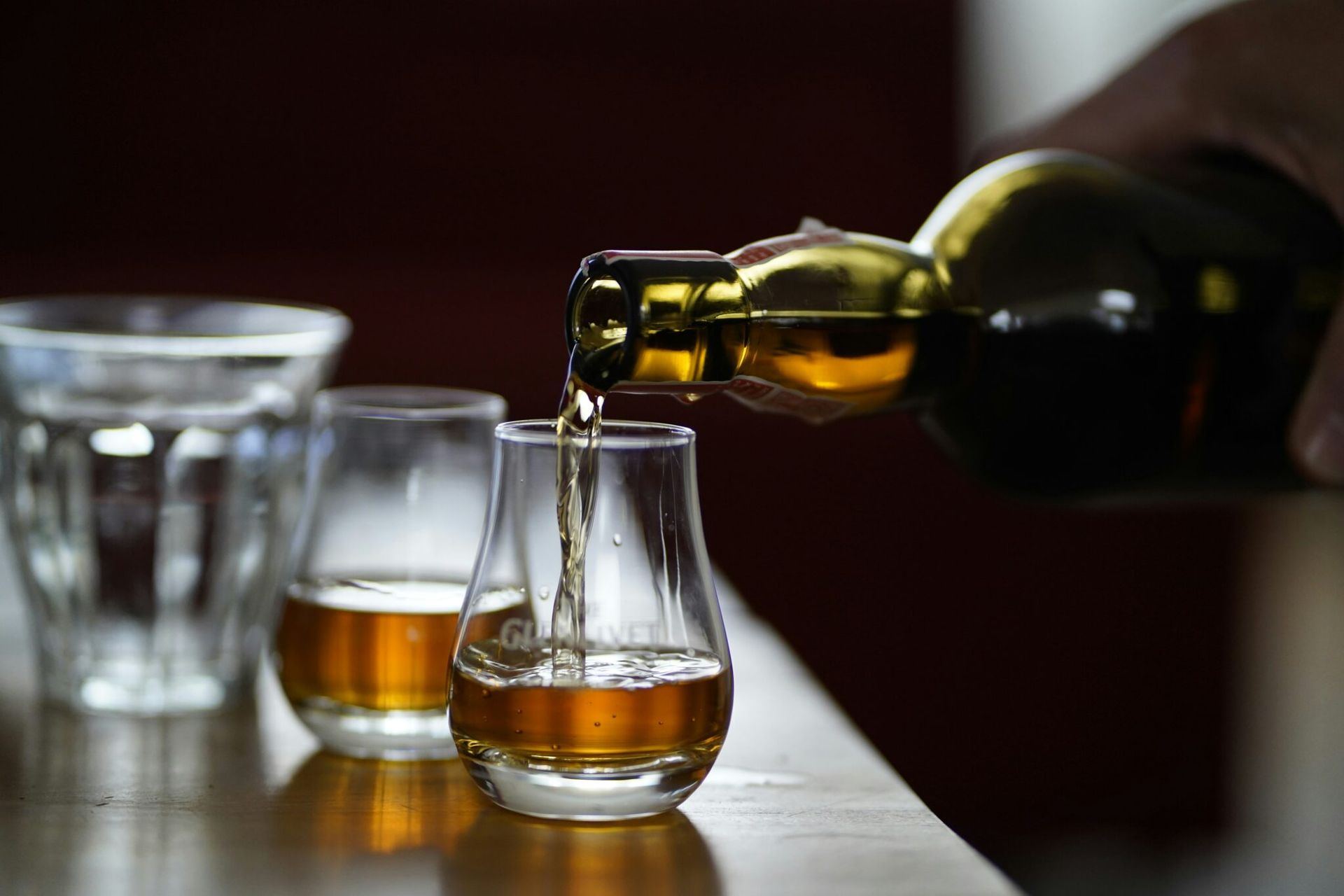 Pouring alcohol in glasses at distillery