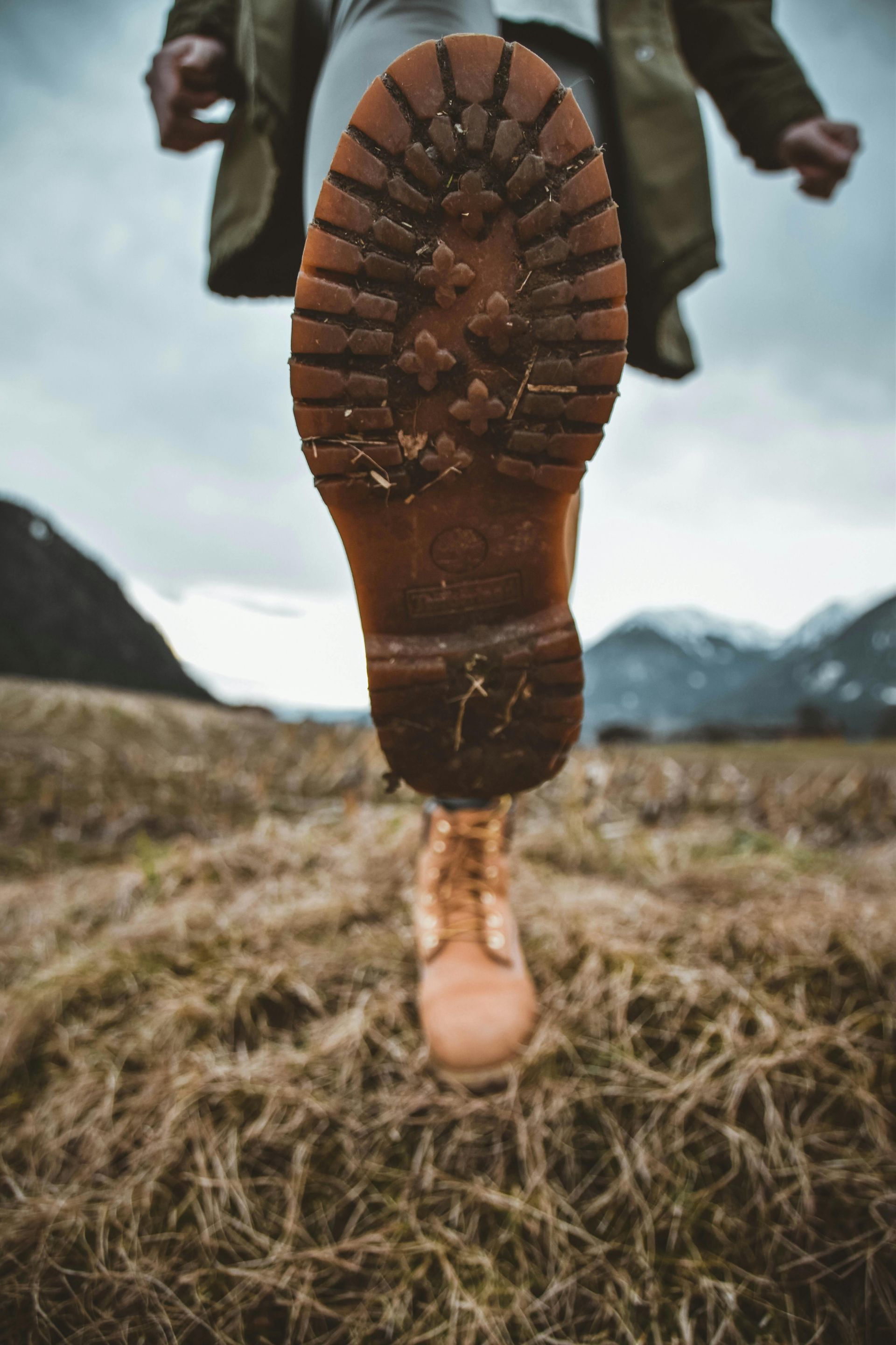 Up close hiker boots with hills and blue skies in the background