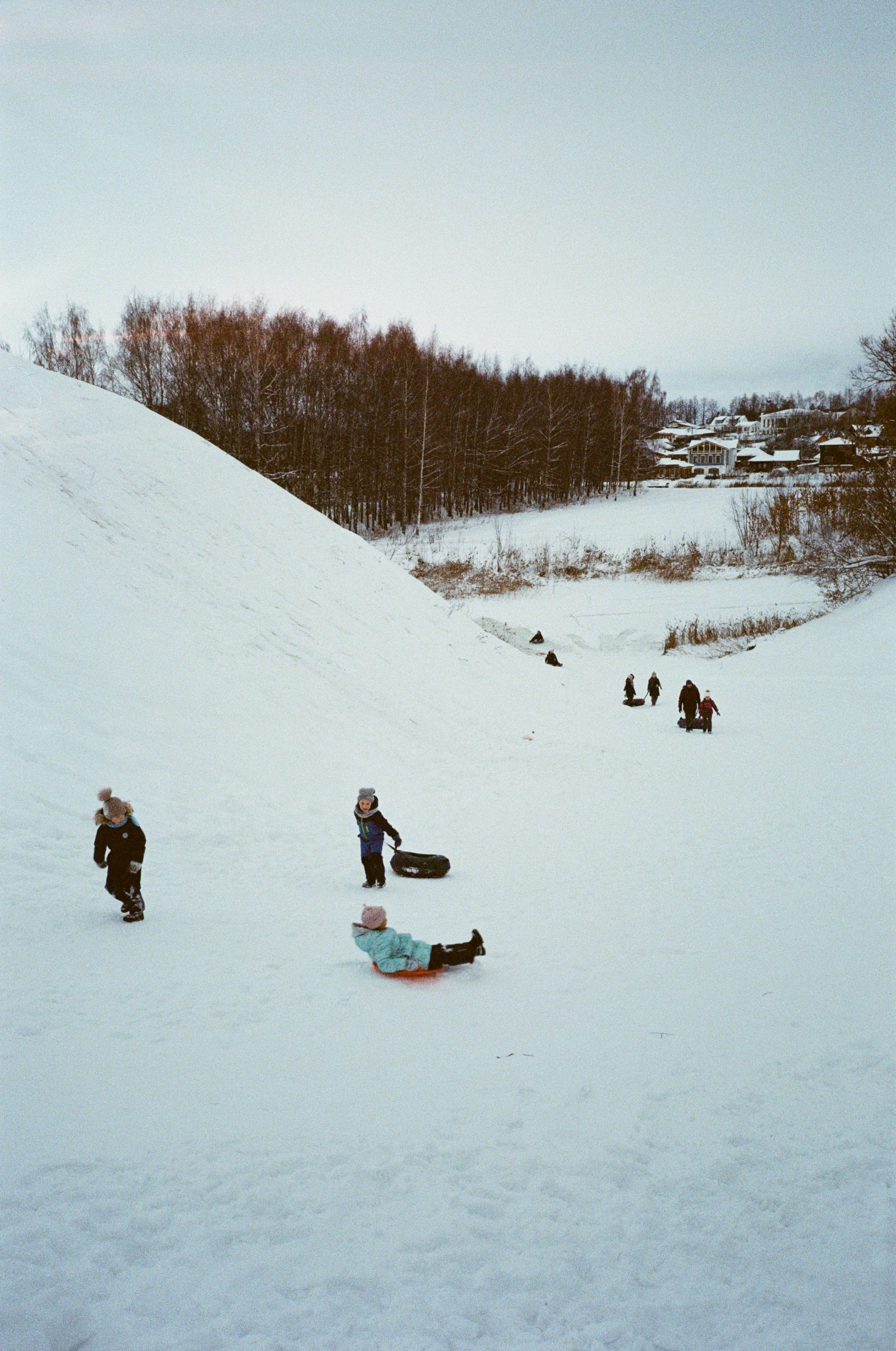 Children sledding down a snow-covered hill