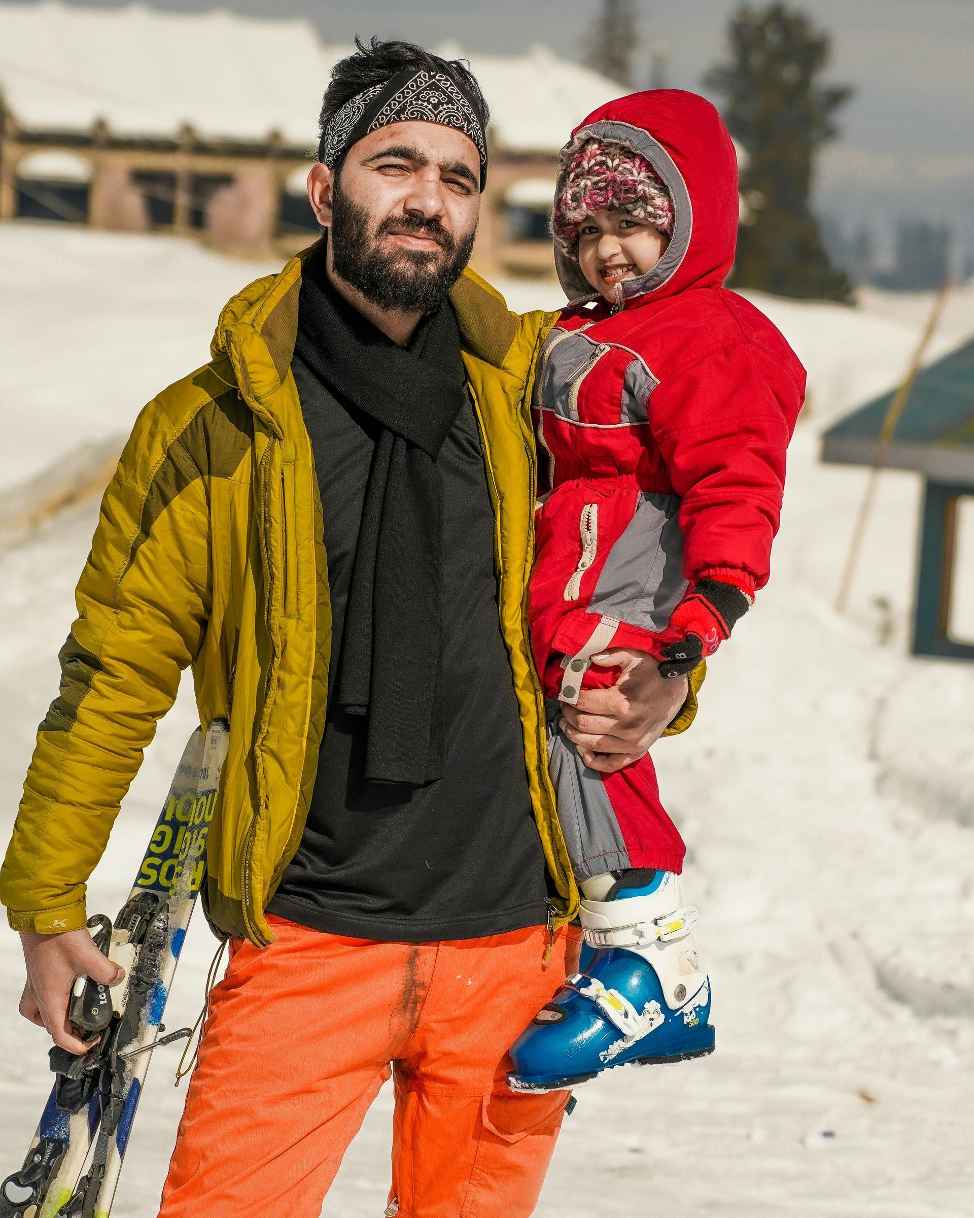 Man and child posing in winter clothing at a ski hill