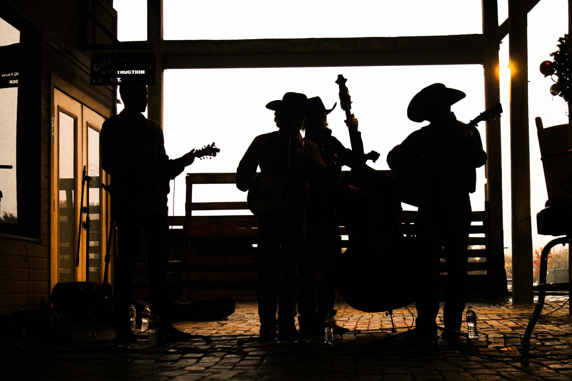 Group of western musicians playing in an outdoor venue under a hot summer day