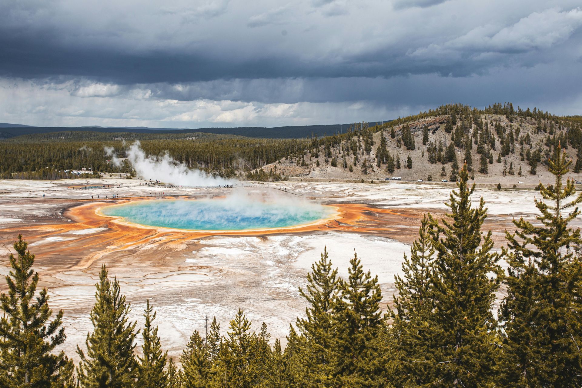 Beautiful blue geyser in the middle of a field surrounded by trees