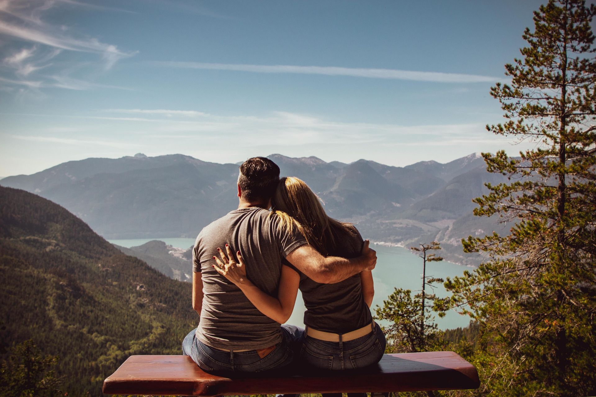 Couple sitting together enjoying scenic views of a lake in the mountains