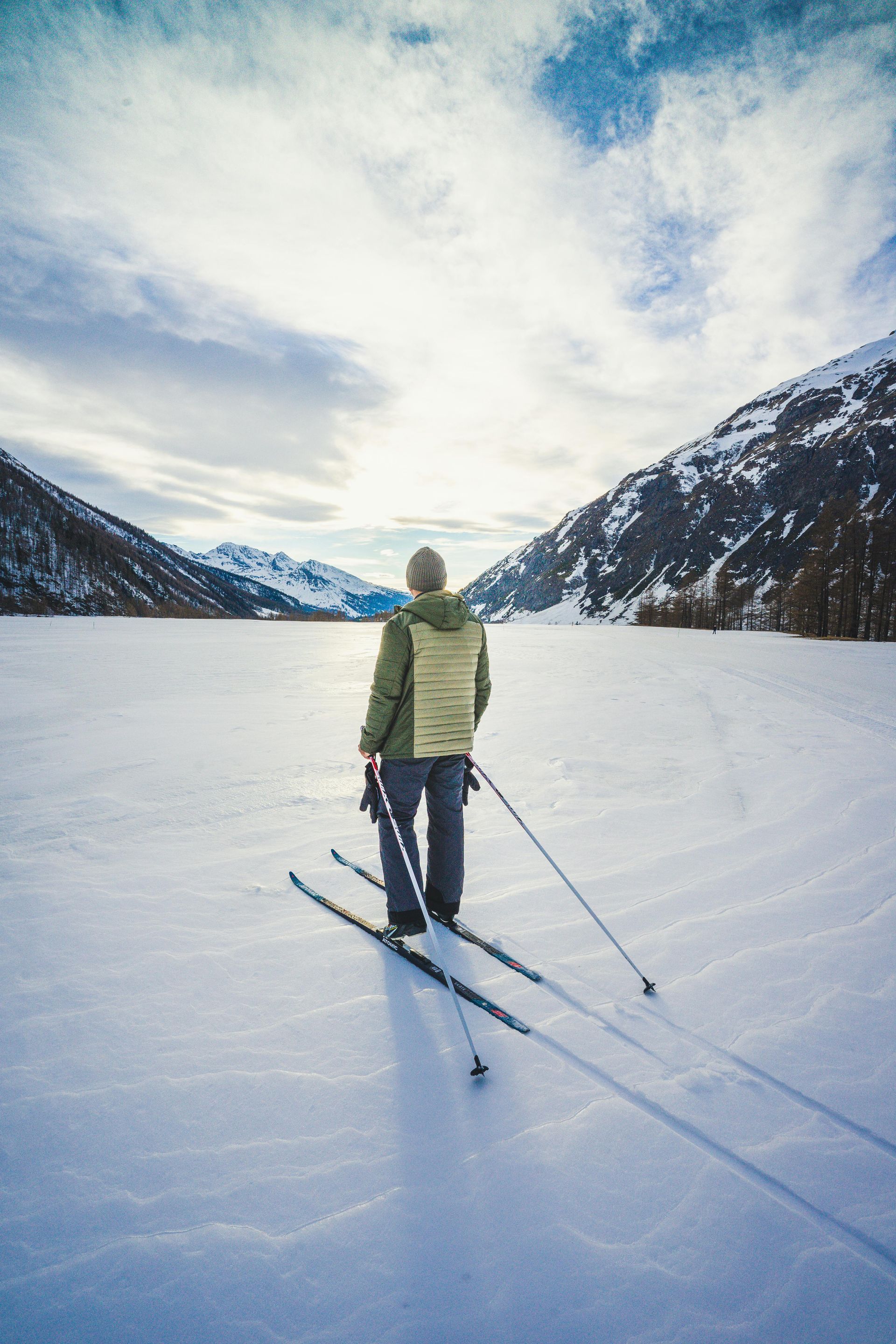 Person standing in the snow with cross-country skis