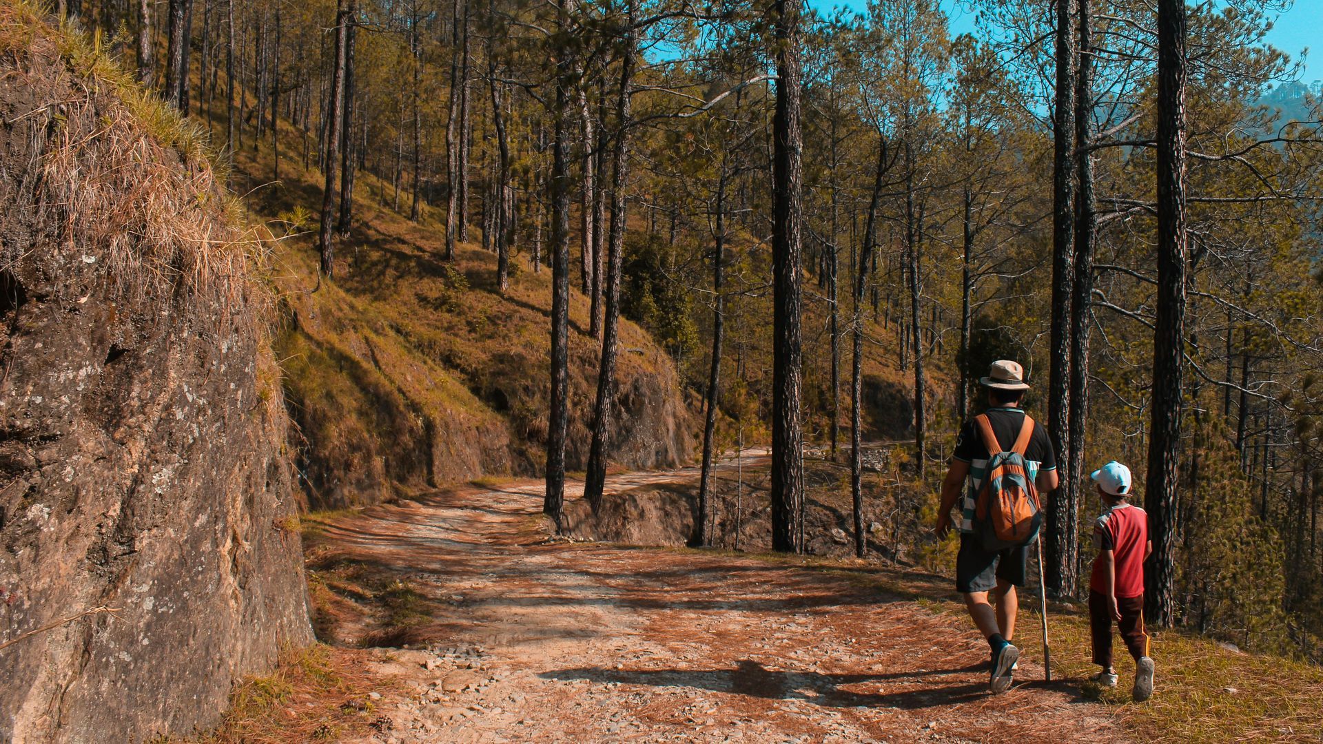 Father & son hiking throughout flat, dirt roads in the Black Hills of South Dakota