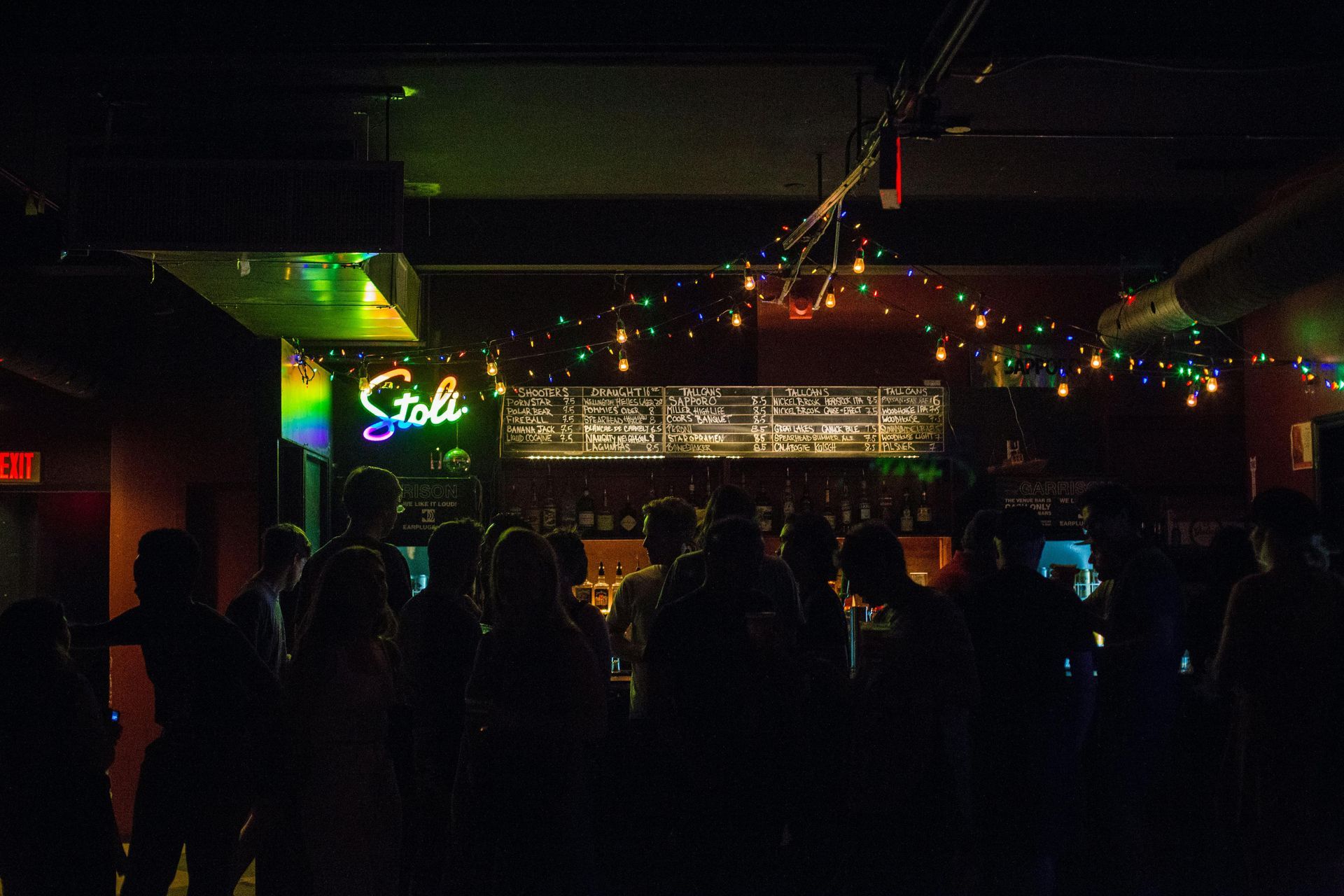 People gathered around a bar with dim lights for evening entertainment