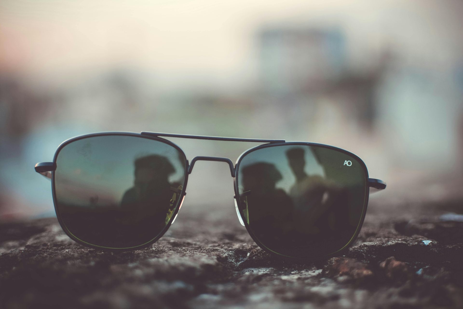 Sunglasses sitting on a rock with reflections in the background