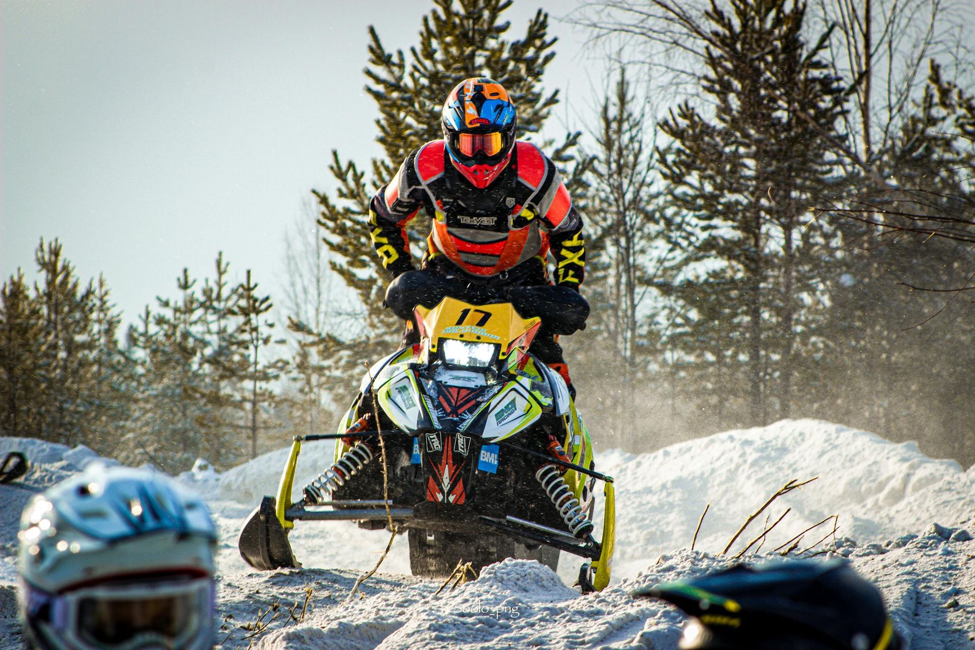 Snowmobiler in gear speeding through a snow-covered trail