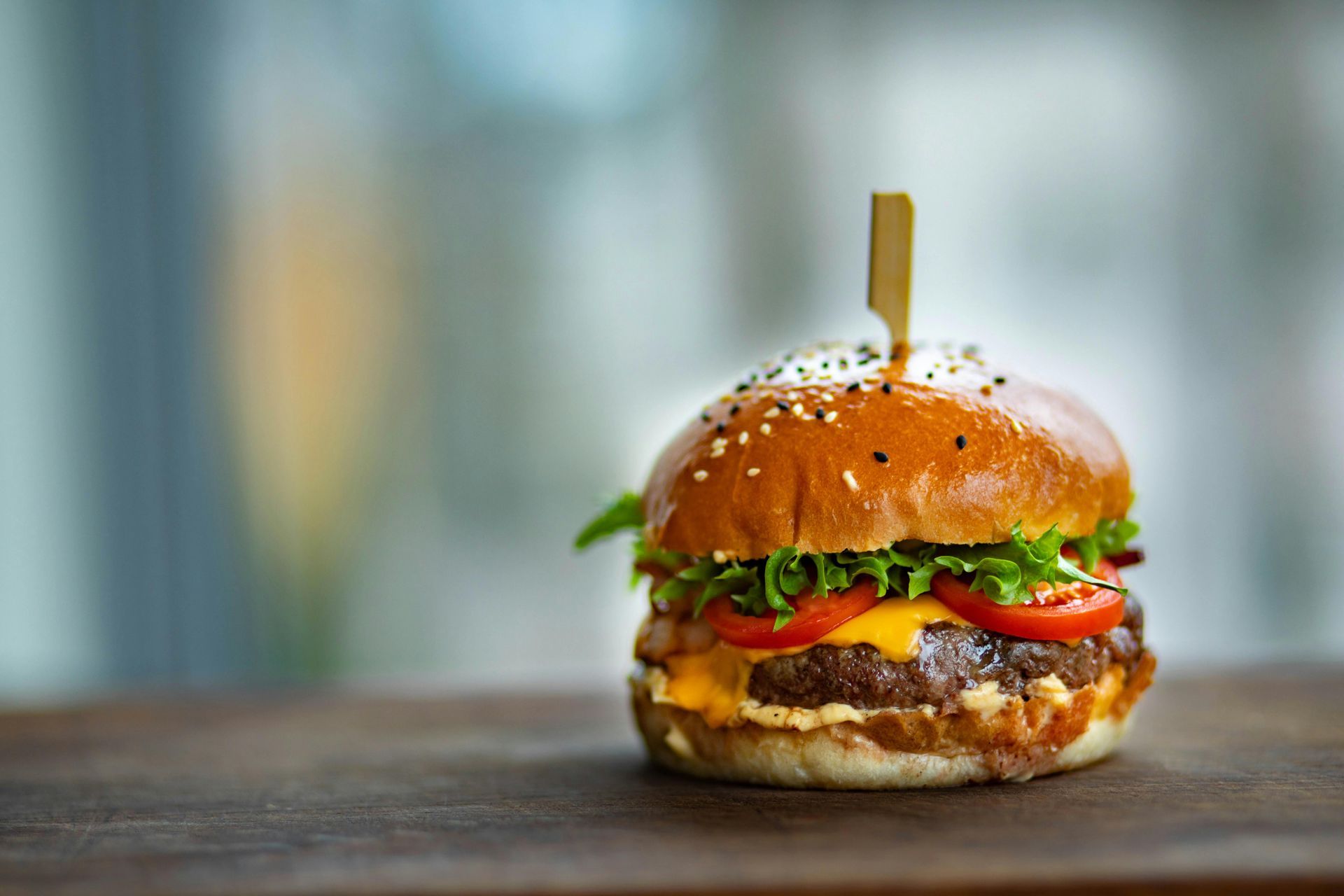 A delicious burger resting on top of a cafe table ready to be served