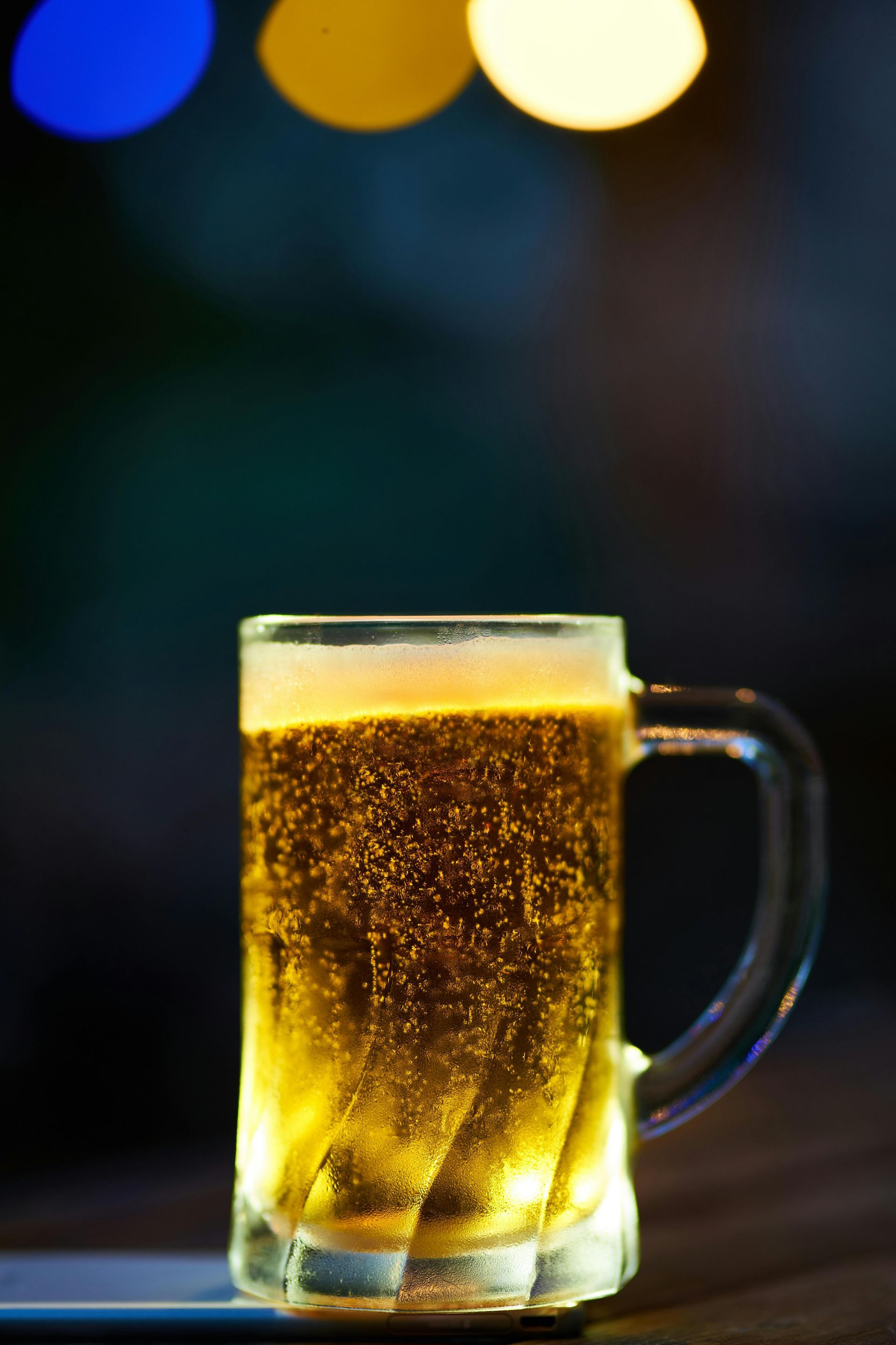 Close up of a mug of beer with bubbles floating to the top of the mug
