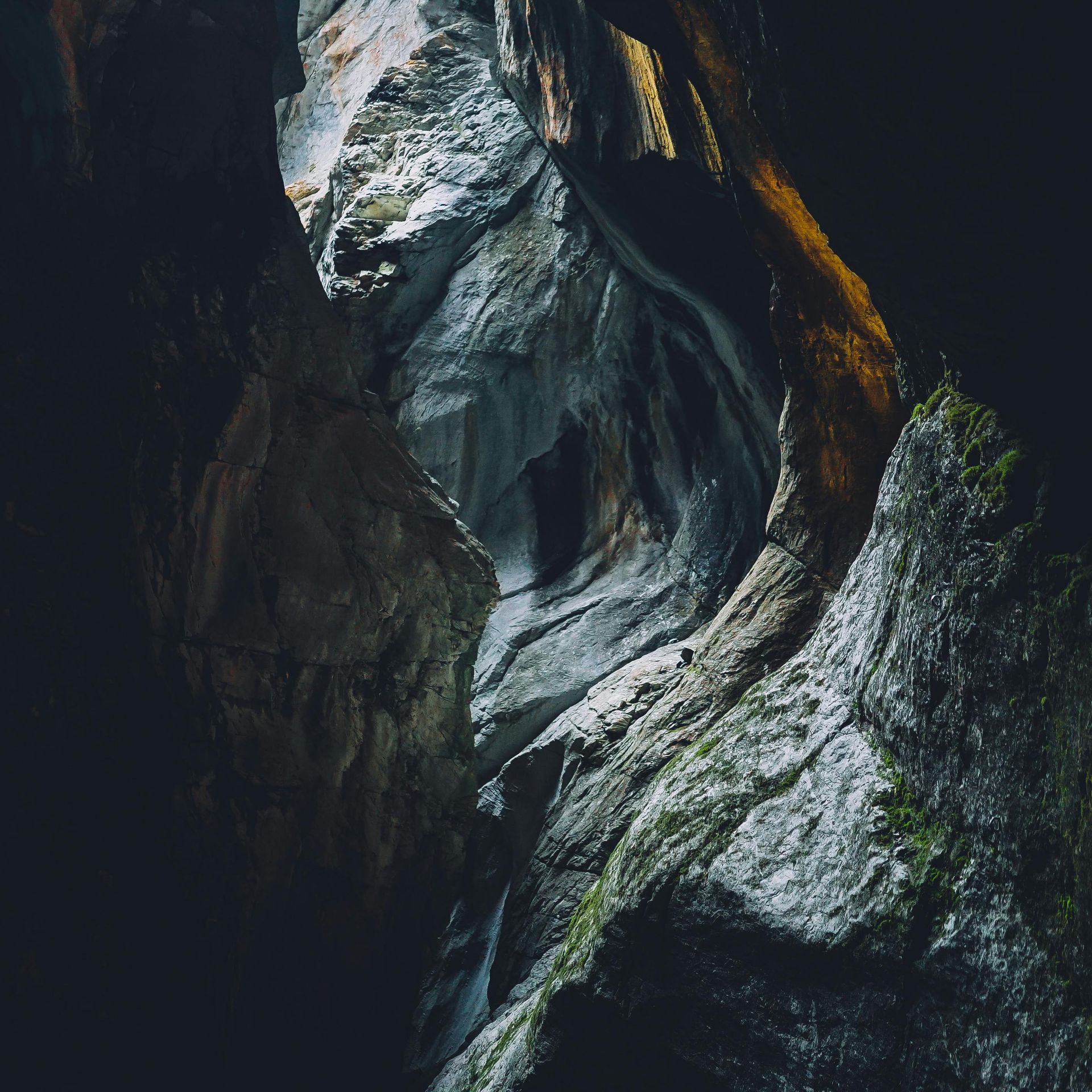 Tunnel in a rock cave with little light shining through