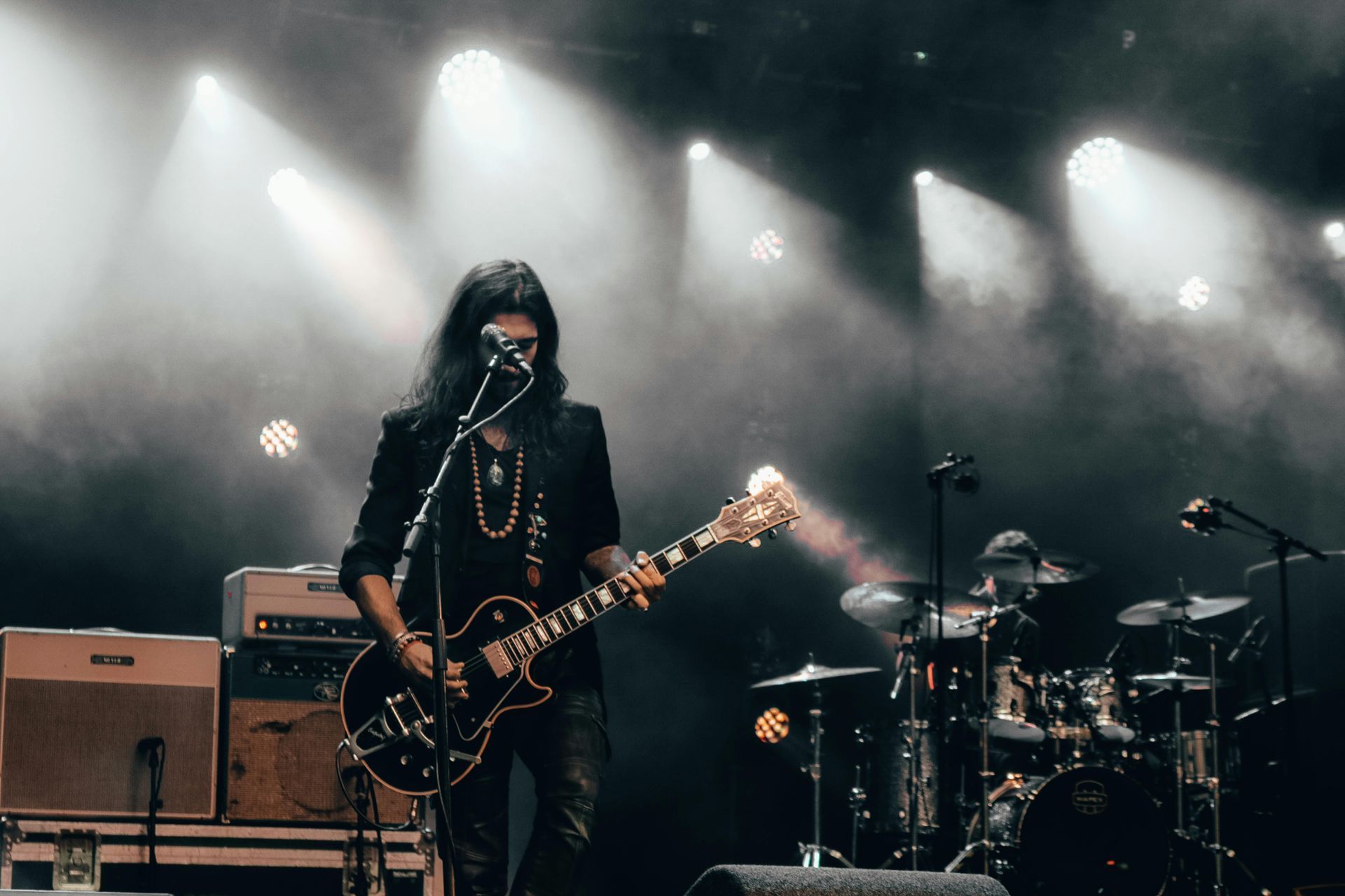 Live music on a stage with guitars, drums, and bright lights