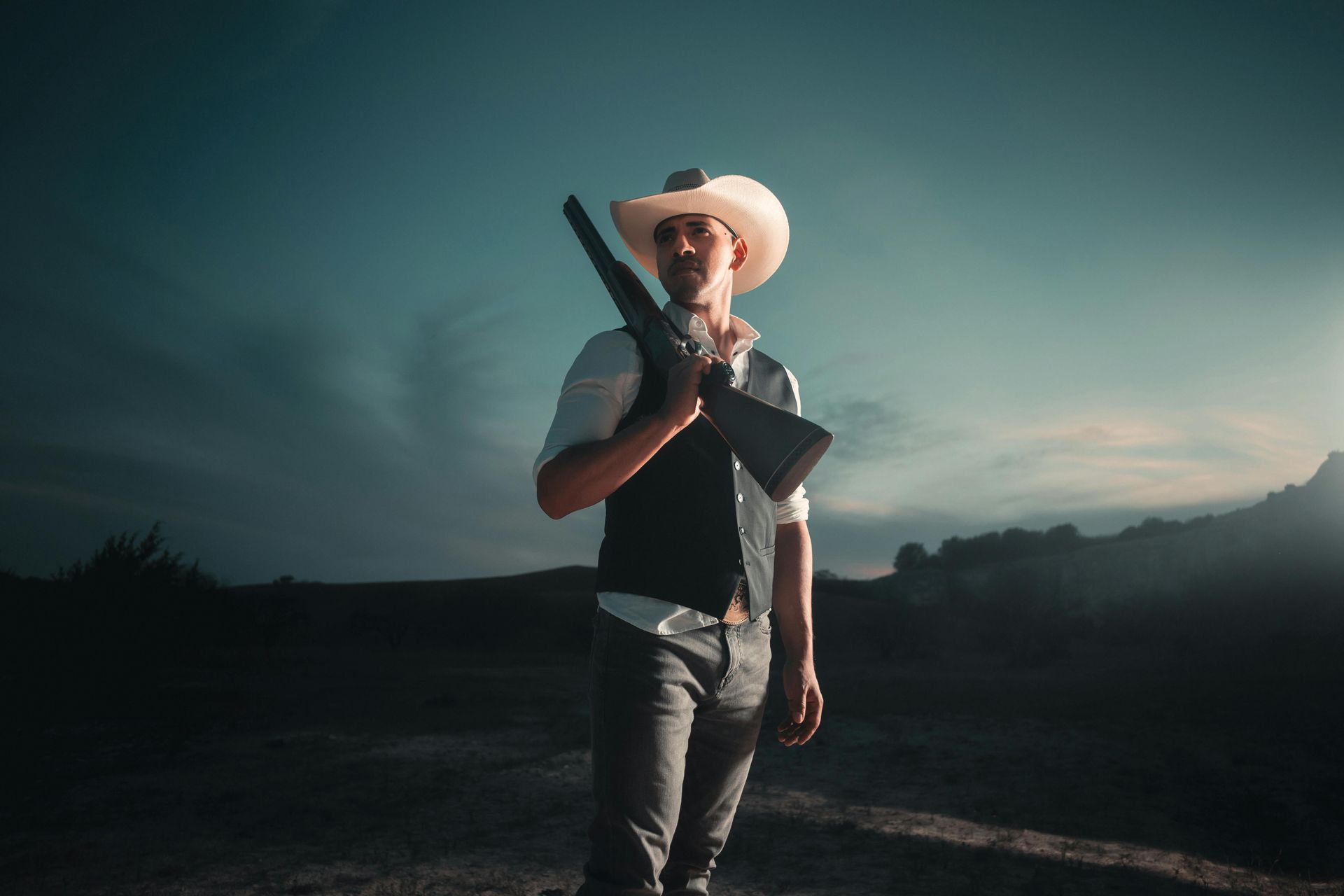 Gunslinger with a rifle over his shoulder during dawn
