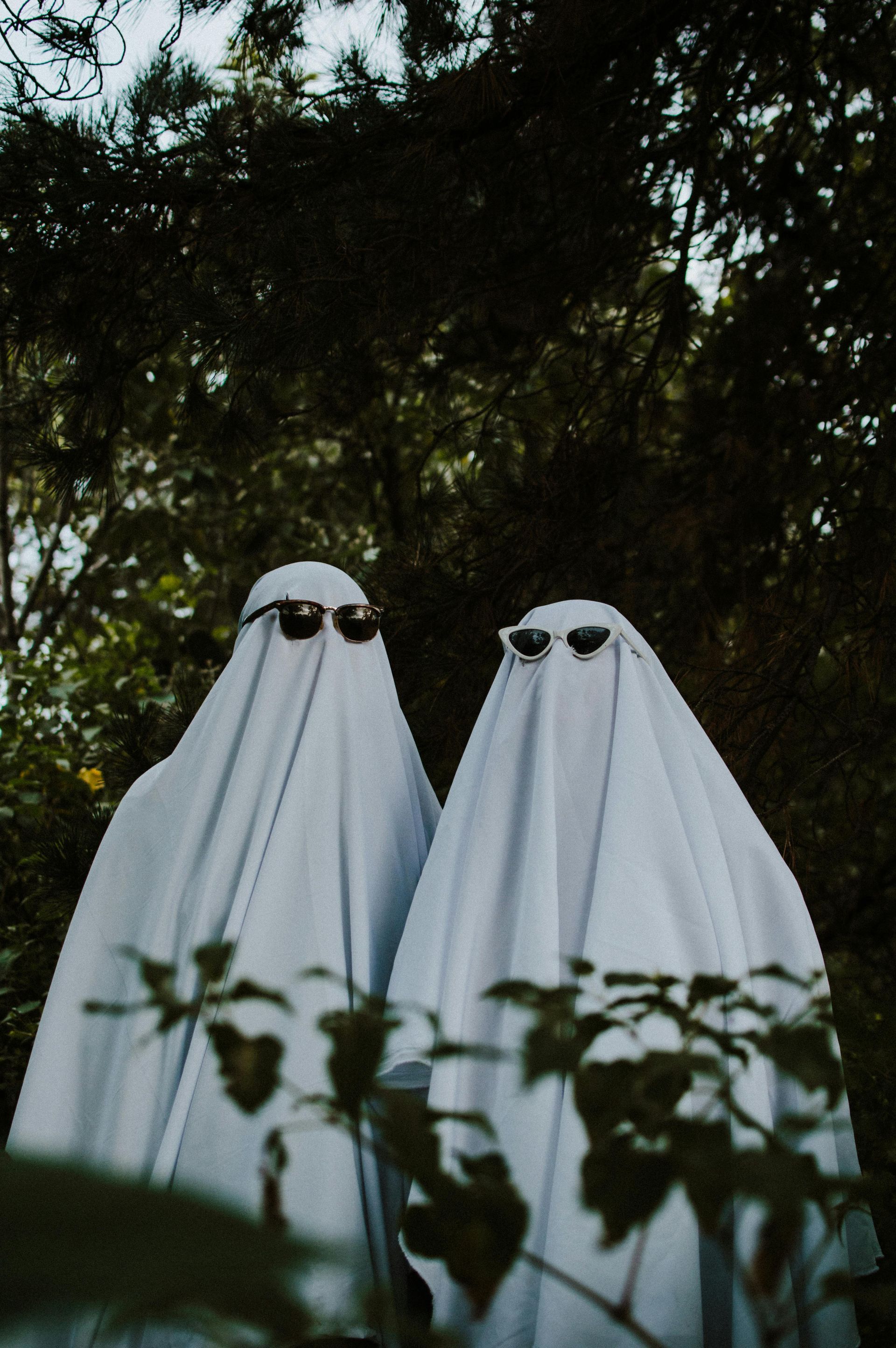 Two ghost with sunglasses outdoors enjoying the spooky season 