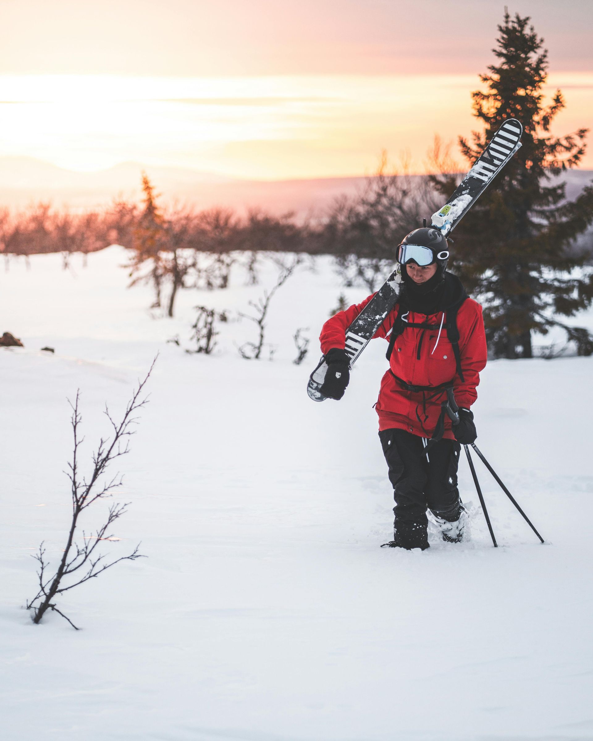 Person carrying cross-country skis throughout the deep snow