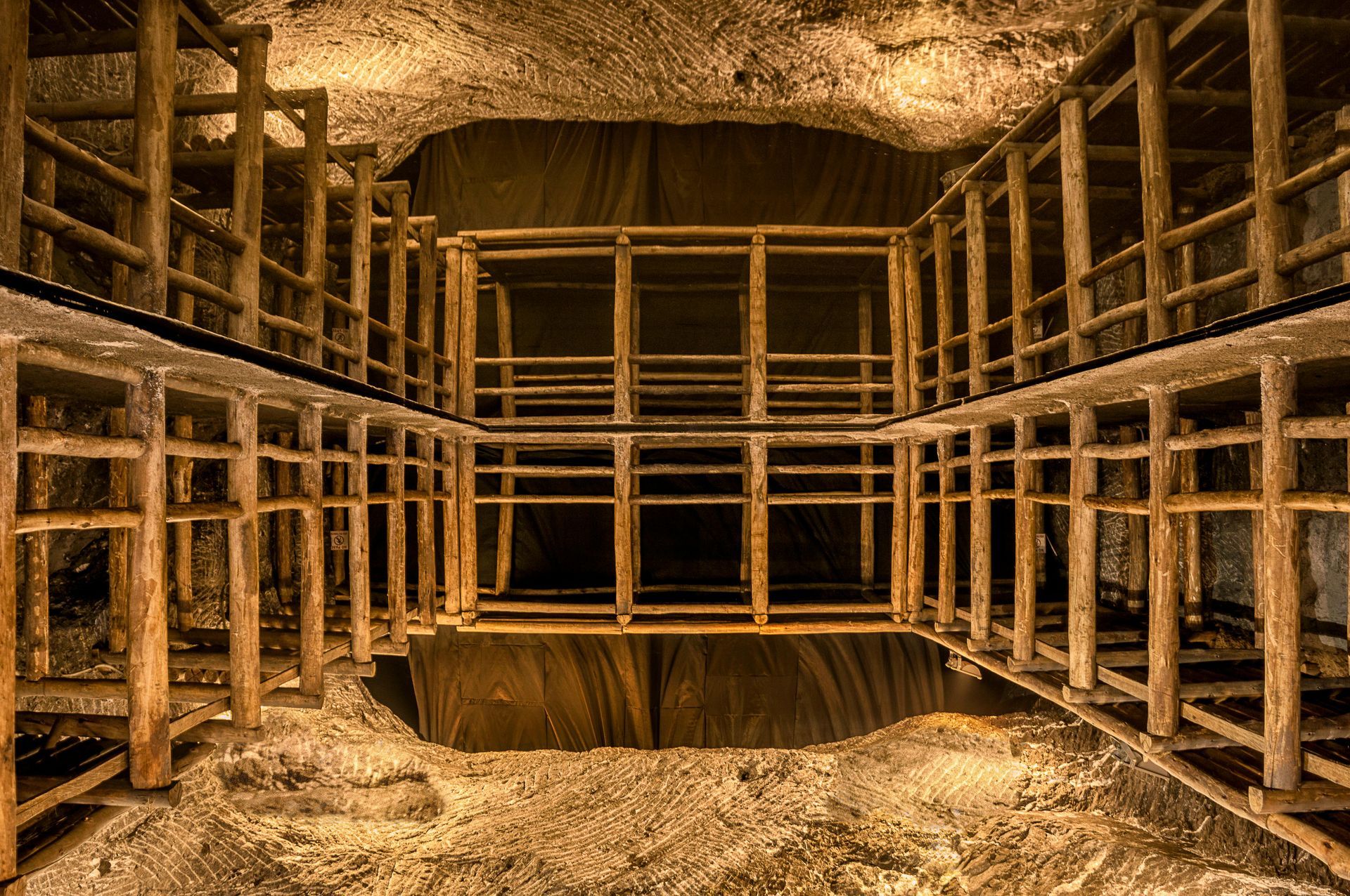 A cavern in an underground mine lit up by glowing lantern light