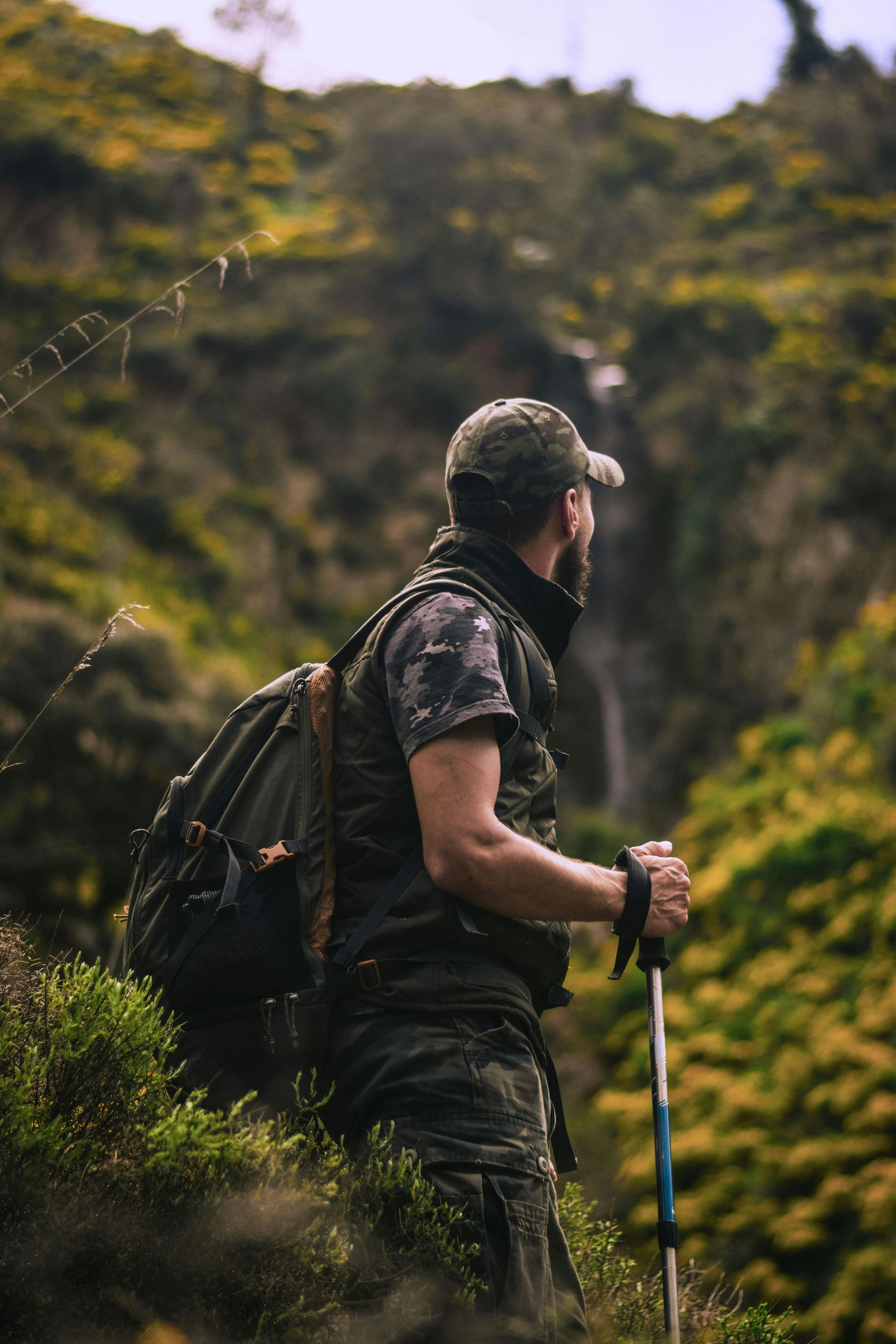Man hiking outdoors with hiking bag and trekking poles
