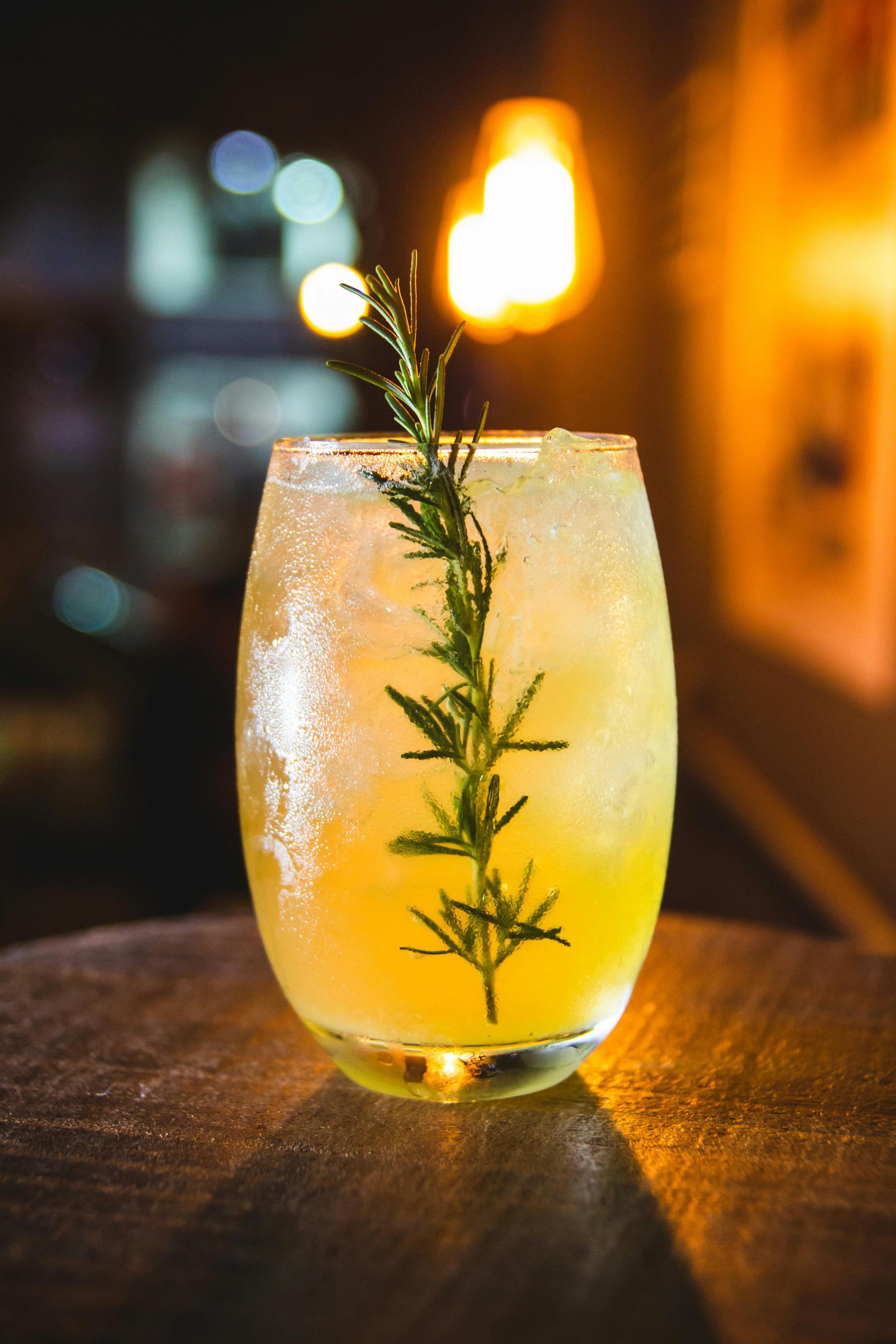 A fruity alcoholic beverage standing on a wooden table in a bar